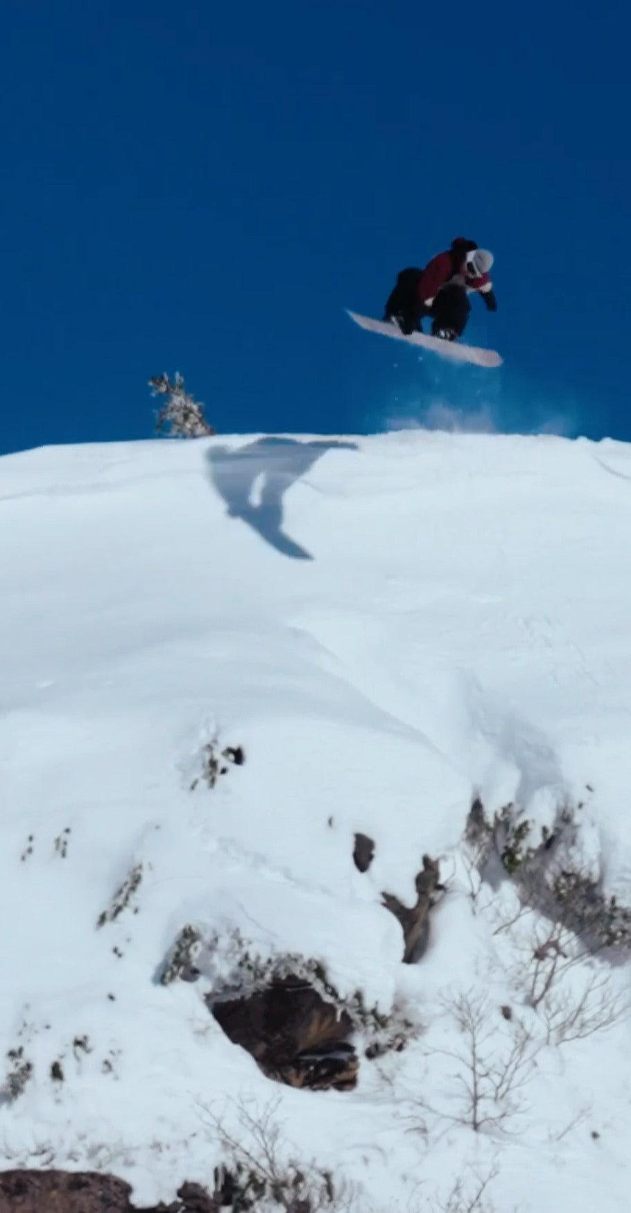 Snowboarder jumping off a snowy ridge