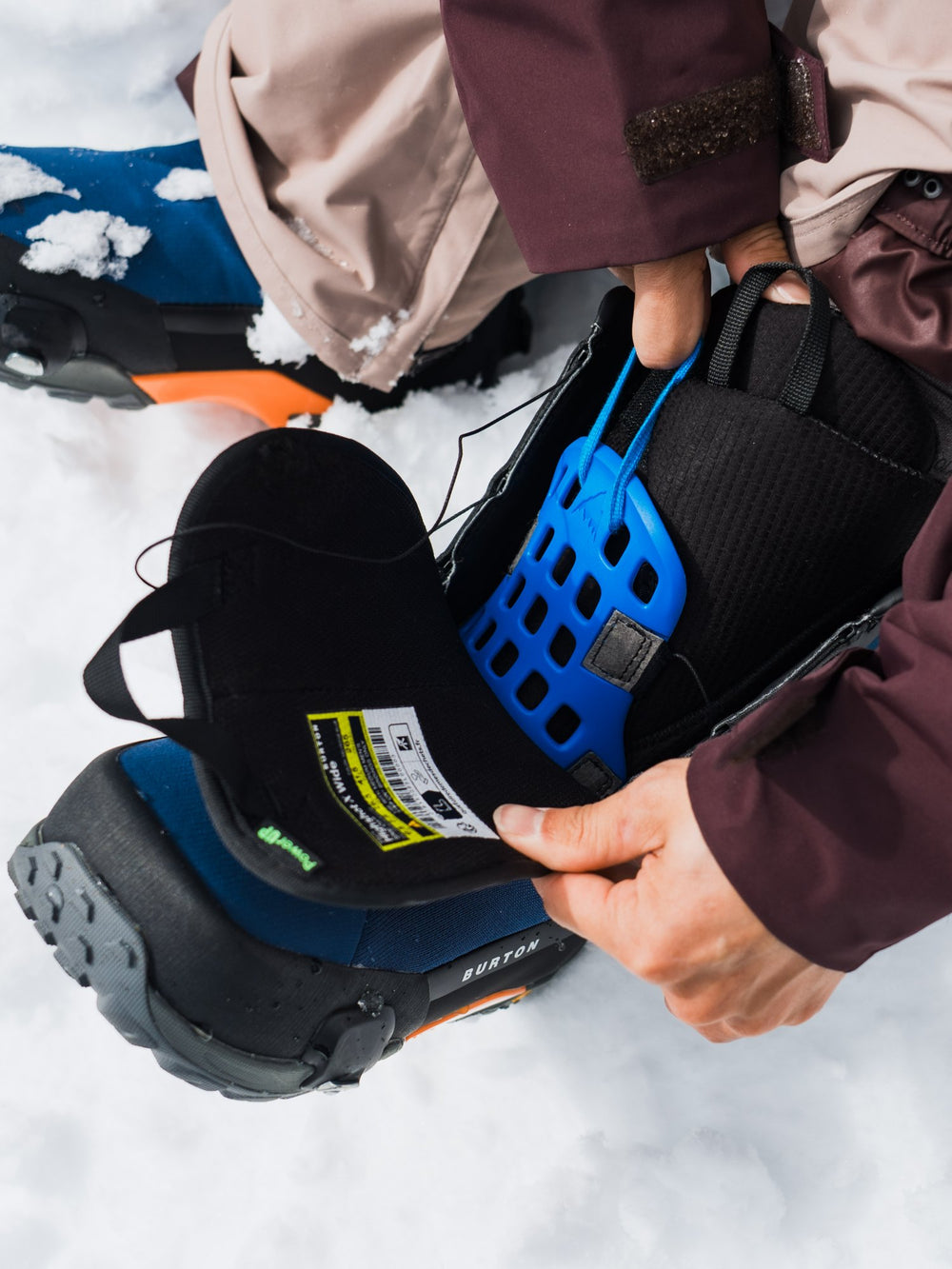 Snowboarder adjusting a Burton boot